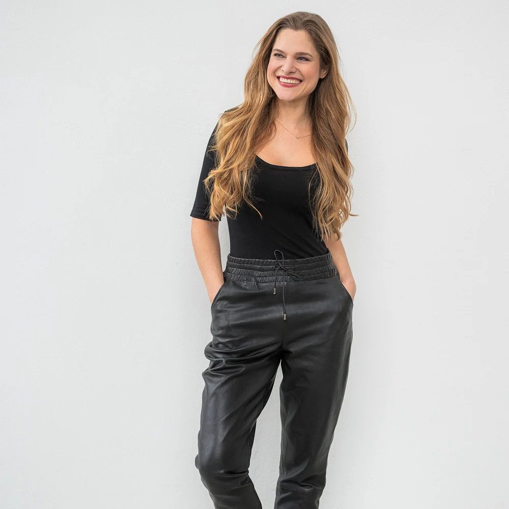 Pantaloni negri din piele naturală cu talie elastică, purtați de model